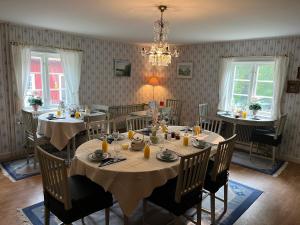 a dining room with tables and chairs and a chandelier at Skagagården-peaceful stay near Tiveden National Park in Undenäs +59 photos
