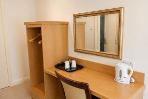 a wooden desk with a mirror and a chair at Wakefield Limes Lodge in Wakefield
