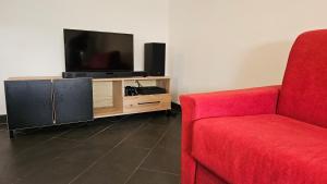 a living room with a red couch and a television at Happy House - Marina Centro in Rimini