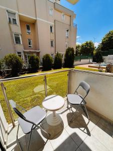 two chairs and a table on a balcony with a building at Byla Central Studio in Byala