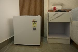 a white refrigerator sitting in a room next to a table at Hotel Surya Inn in Khagaul