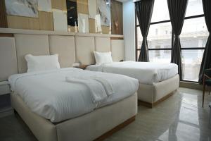 a hotel room with two beds and a window at Hotel Surya Inn in Khagaul