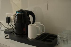 a black appliance sitting on a counter with two cups at Hotel Surya Inn in Khagaul +22 photos