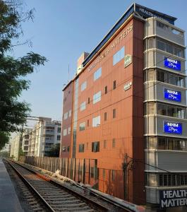 a building with a train tracks in front of it at NHM Stays in Garui