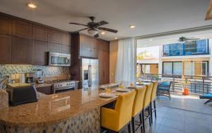 a kitchen with a long bar with yellow chairs at Suites at Zona Romantica in Puerto Vallarta