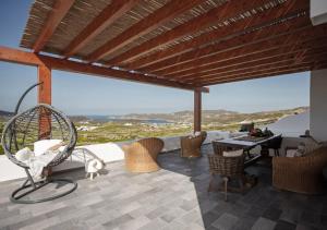 a patio with chairs and a table with a view at Ktima Lipsi, Panorama Pool Views in Klouvas