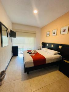 a bedroom with a large bed with a red blanket at Apartment with Pool, Gym & A/C Suite in Querétaro +16 photos