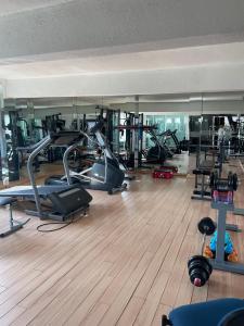 a gym with several treadmills and cardio machines at Apartment with Pool, Gym & A/C Suite in Querétaro