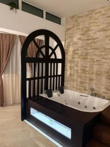 a bath tub in a room with a brick wall at Apartmani Harmonija in Vrbas +21 photos