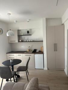 a living room with a table and chairs and a kitchen at Apartmani Harmonija in Vrbas