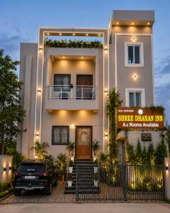 a building with a car parked in front of it at Stay By Shree Dharan Inn Near Shree Ram Mandir Ayodhya in Ayodhya