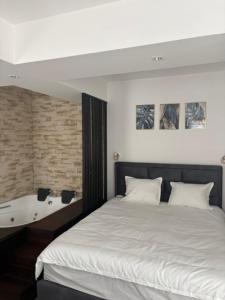 a bedroom with a large bed with a white bedspread at Apartmani Harmonija in Vrbas