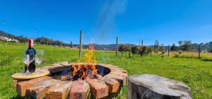 a fire pit with a bottle of wine and a glass at Cabaña Pantano de Vargas con fogata y parrilla privado in Tibasosa