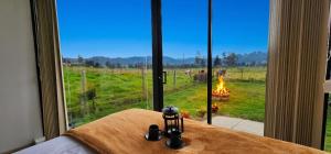 a bedroom with a view of a field and a fireplace at Cabaña Pantano de Vargas con fogata y parrilla privado in Tibasosa