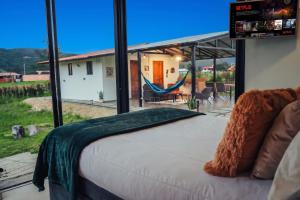 a bedroom with a bed and a view of a yard at Cabaña Pantano de Vargas con fogata y parrilla privado in Tibasosa +55 photos
