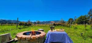 a table and a fire pit in a field at Cabaña Pantano de Vargas con fogata y parrilla privado in Tibasosa
