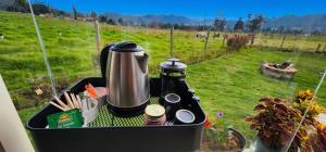 a coffee maker sitting on a table with a view of a field at Cabaña Pantano de Vargas con fogata y parrilla privado in Tibasosa