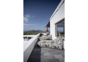 a balcony with a couch and chairs on a house at Ktima Lipsi, Panorama Pool Views in Klouvas +60 photos
