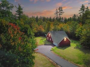 a red barn in the middle of a road at White Mountain Dream Cabin in Fryeburg