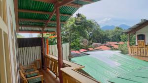 a balcony of a house with a green roof at Luminous Haven Atitlan #1 in San Marcos La Laguna