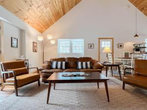 a living room with a couch and a table at White Mountain Dream Cabin in Fryeburg