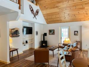 a living room with a couch and a table at White Mountain Dream Cabin in Fryeburg