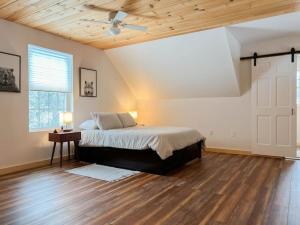 a bedroom with a bed and a ceiling fan at White Mountain Dream Cabin in Fryeburg