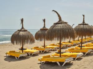 a row of chairs and umbrellas on a beach at Kimpton Los Monteros Marbella by IHG in Marbella