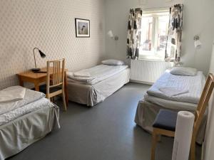 a room with three beds and a table and a desk at Gefle vandrarhem in Gävle +25 photos