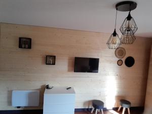 a room with a wall with a television and two stools at Studio pistes La Bresse Hohneck in La Bresse