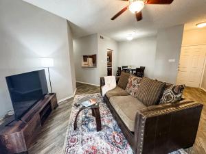 a living room with a couch and a flat screen tv at Spacious Poolside Oasis - Easy Access and Garage in Corpus Christi