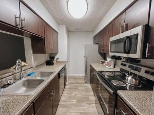 a kitchen with a sink and a stove at Spacious Poolside Oasis - Easy Access and Garage in Corpus Christi
