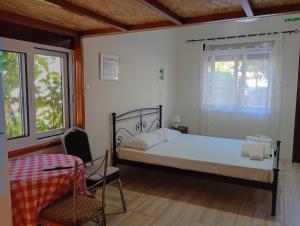 a bedroom with a bed and a chair and a window at Lily's Studios in Nikiana