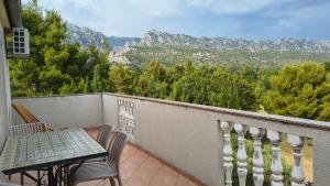 a balcony with a table and chairs and mountains at Apartmani Nina in Starigrad