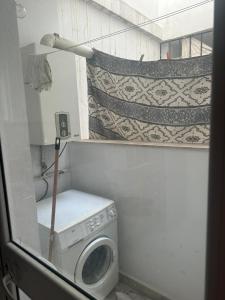 a bathroom with a washing machine and a lamp at Appartement Sousse in Hammam Sousse