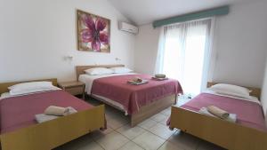 a bedroom with two beds and a window at Apartmani Nina in Starigrad