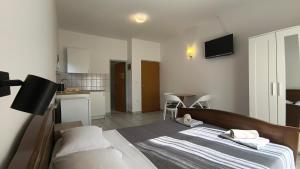 a bedroom with a large bed and a kitchen at Apartmani Nina in Starigrad