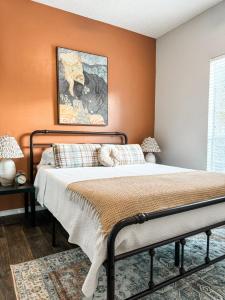 a bedroom with a bed with an orange wall at Pool View Escape - Near Shops and Dining in Corpus Christi