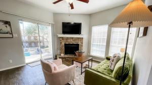 a living room with a green couch and a fireplace at Pool View Escape - Near Shops and Dining in Corpus Christi +25 photos