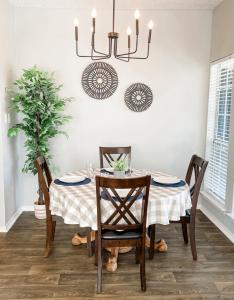 a dining room with a table with chairs and a chandelier at Pool View Escape - Near Shops and Dining in Corpus Christi