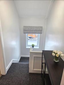 a room with a table and a window with a window shade at Newly Refurbished Townhouse in Derry Londonderry +10 photos