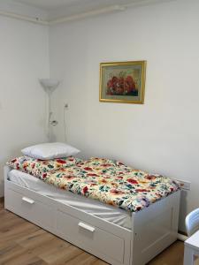 a bed in a bedroom with a flowery comforter at Haromfa Apartman in Háromfa