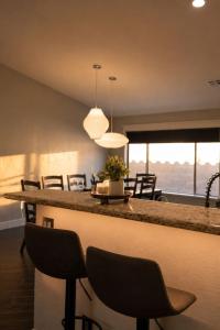 a kitchen and living room with a bar with chairs at Desert Disconnect Outdoor Cinema and Pool in Mesa