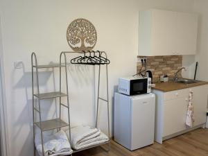 a kitchen with a refrigerator and a microwave at Haromfa Apartman in Háromfa
