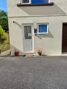 a house with a white door and two potted plants at The Shack 1 bedroom apartment in Newquay
