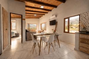 a kitchen with a dining room table and chairs at Amplios Departamentos con Vistas a los cerros - Patio, Asador y Pileta in Tafí del Valle