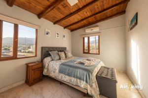 a bedroom with a bed and a window at Amplios Departamentos con Vistas a los cerros - Patio, Asador y Pileta in Tafí del Valle +22 photos