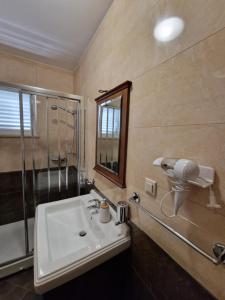 a bathroom with a sink and a shower and a mirror at Blue Diamond Rooms in Zaton +27 photos