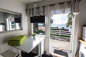 a small room with a white desk and a window at Airisto Hill & Inn - Two Beach Cabins in Haverö