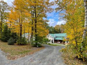 a road in front of a house with trees at Authentic VT Chalet, Hot tub, Fire pit, Mt Snow in Dover
